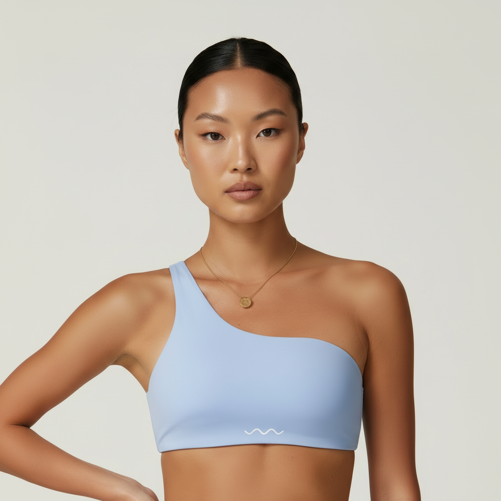 Baby blue one-shoulder crop top - close-up with hand on hip