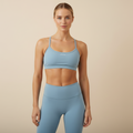 Blue sports bra on model - cream background