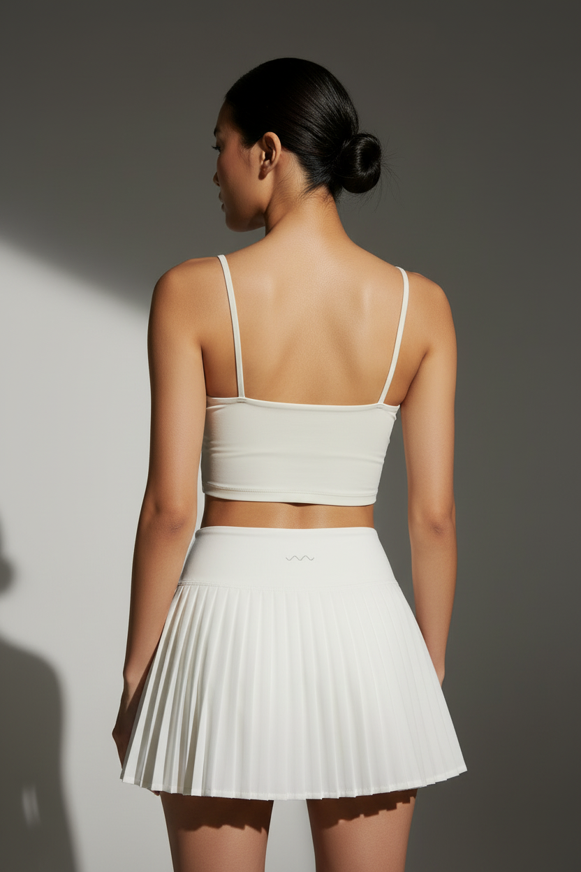 White pleated skirt back view with logo on waistband